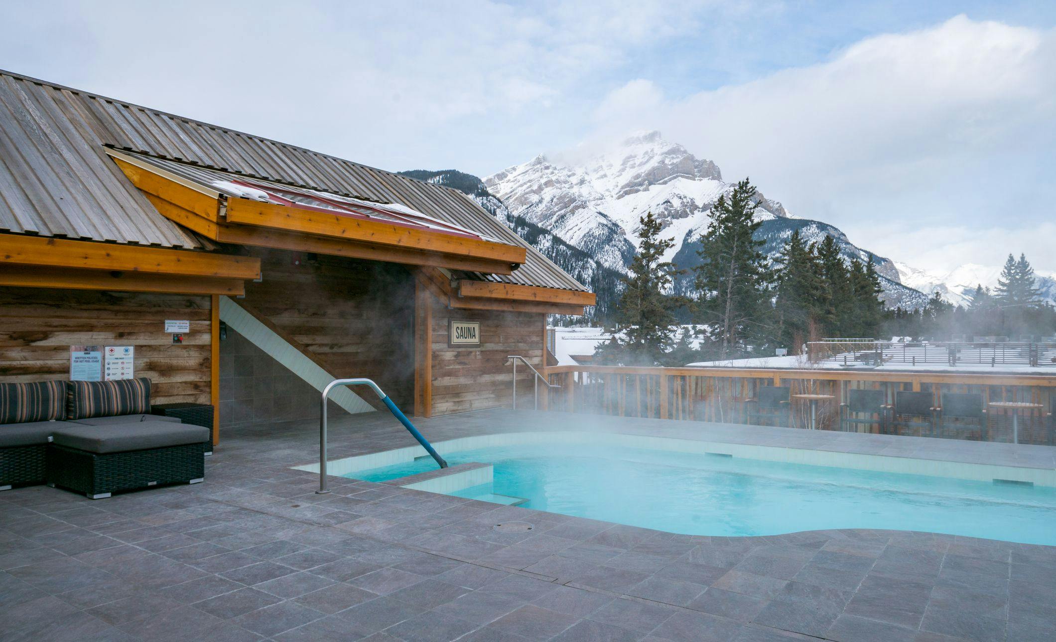 Rooftop Hot Tub &amp; Lounge Area with Snow-Capped Mountain Peak in the Background