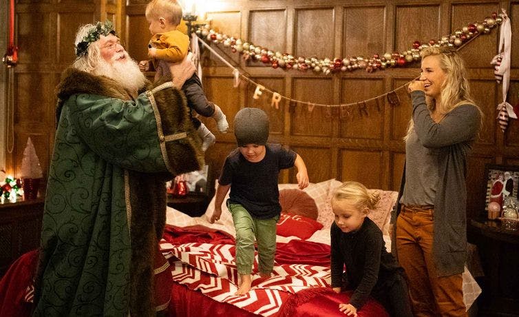 Three kids play with Santa Claus in the Santa suite at the Banff Springs Hotel in Banff National Park.