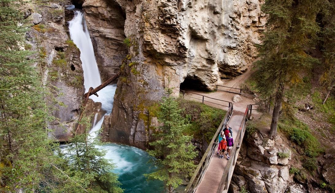 Hikers stand on a catwalk near the lower falls of Johnston's Canyon.