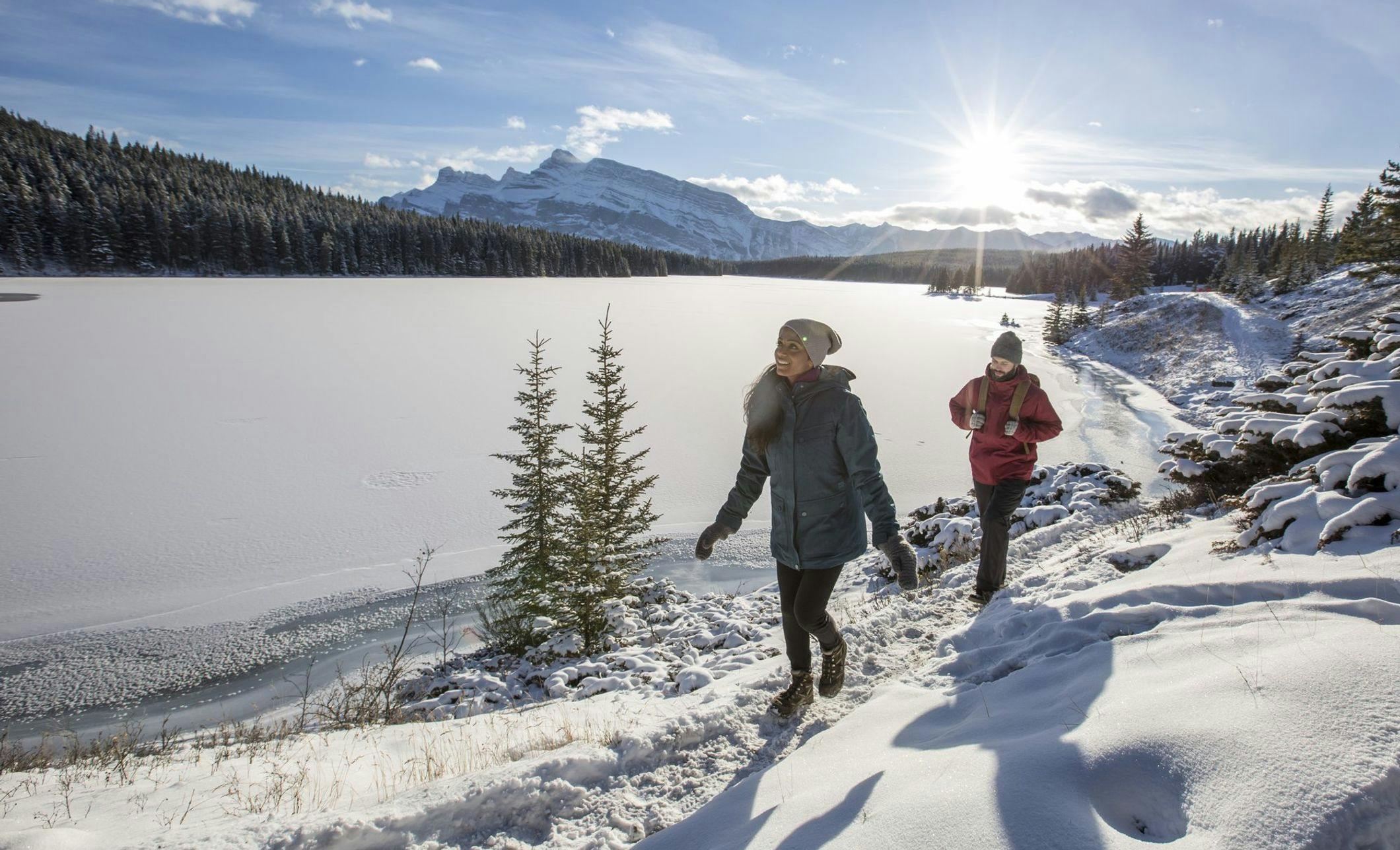 A couple enjoying a winter hike around a frozen lake