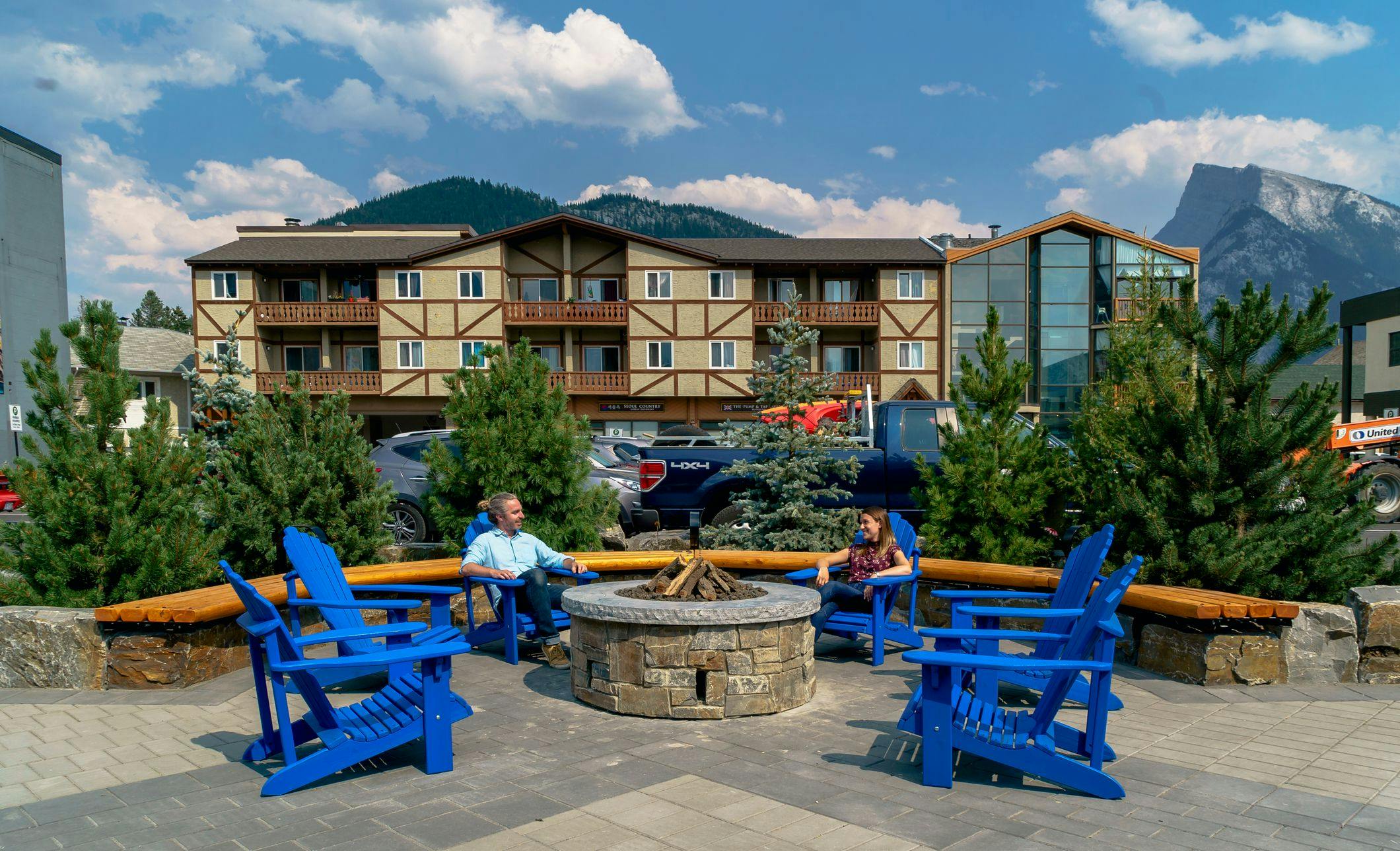 Blue chairs around a gas firepit on the new Bear Street in Banff, Alberta.