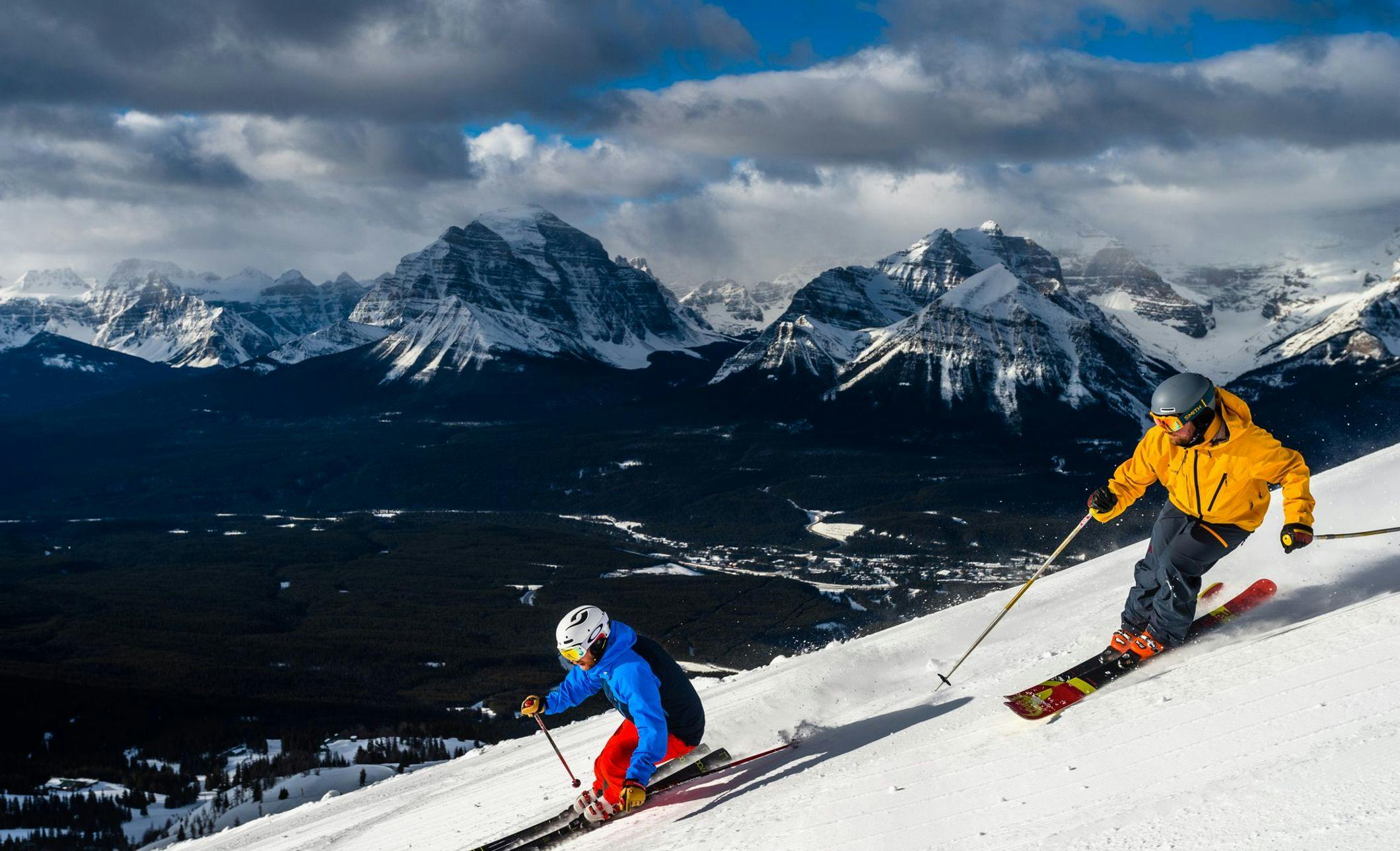 Two skiiers traveling down a mountain at the Lake Louise Ski Resort