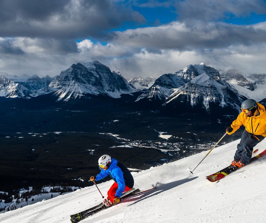 Two skiiers traveling down a mountain at the Lake Louise Ski Resort