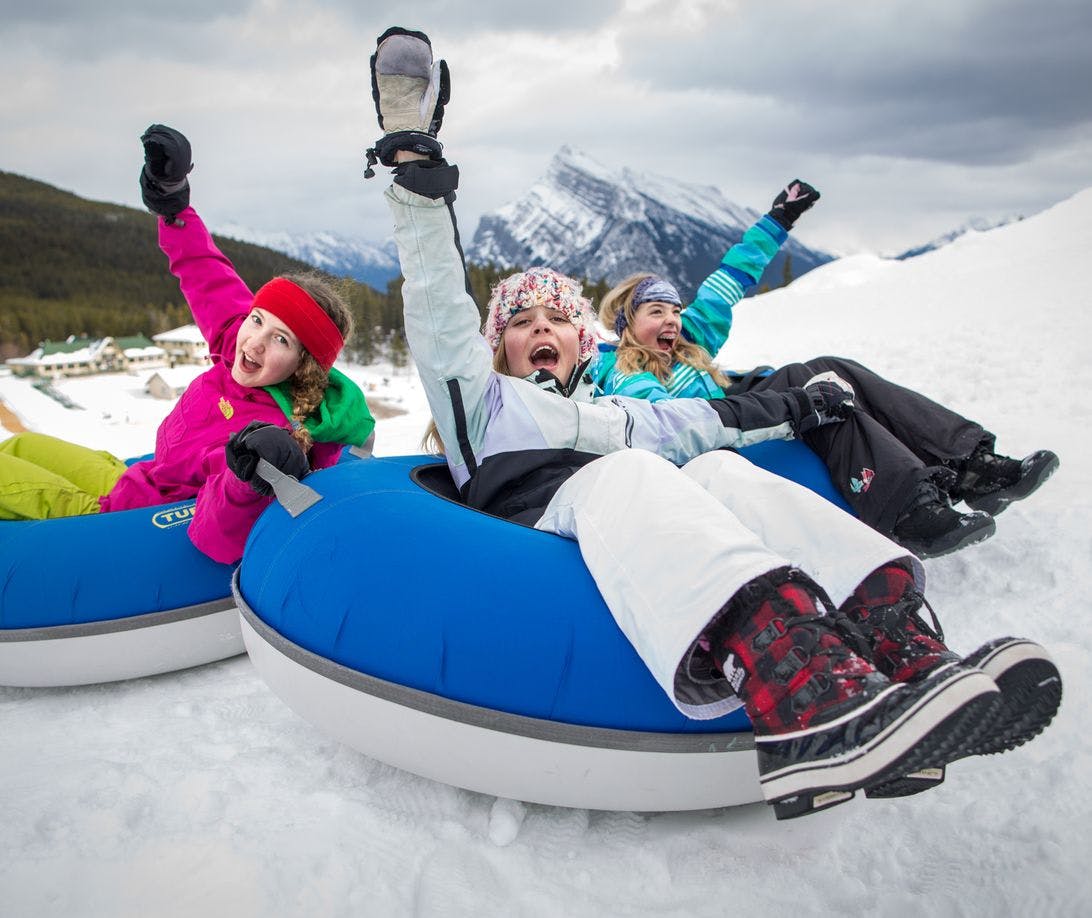 A group of girls tubes down the snowy slops of Banff and Lake Louise, AB