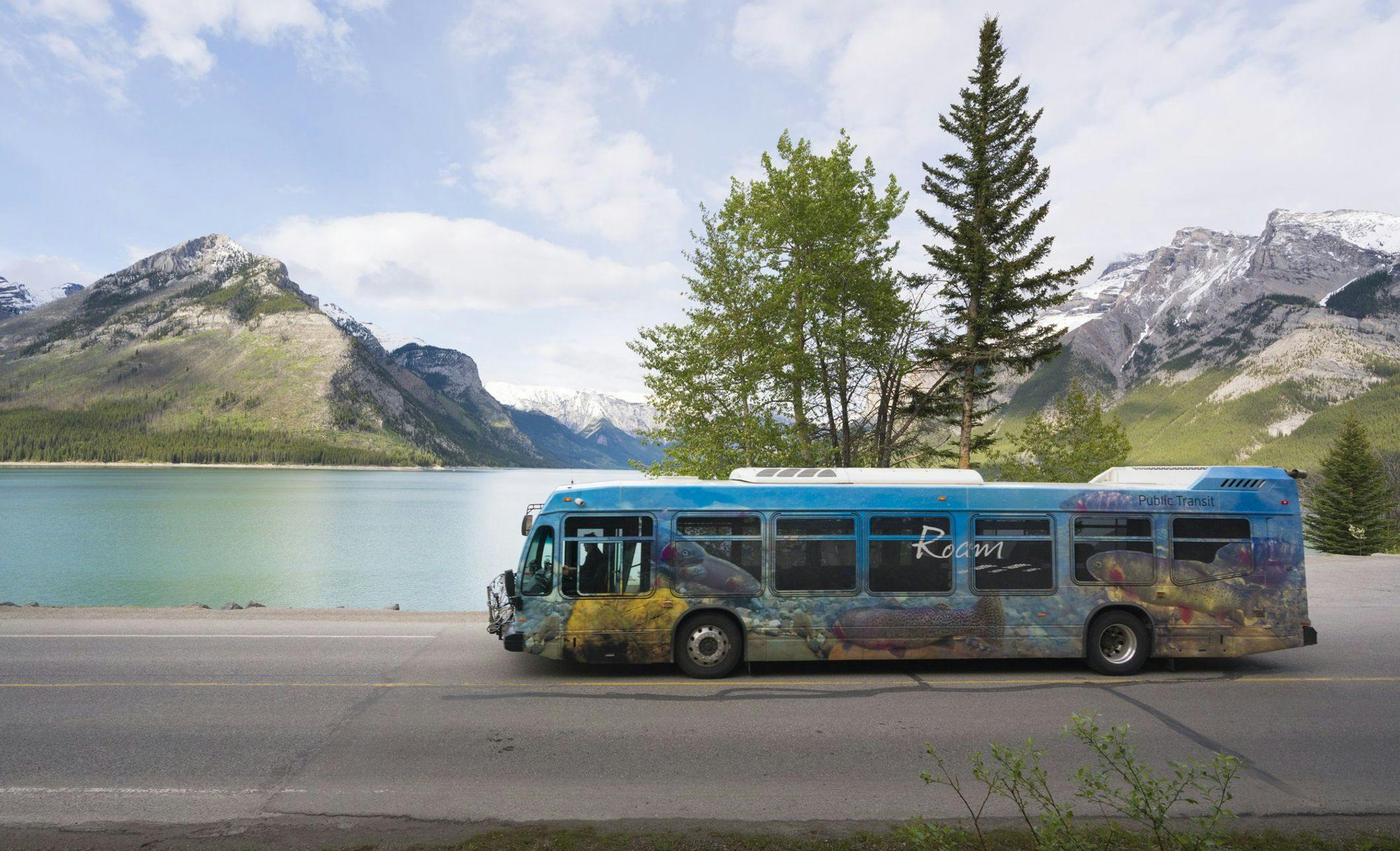 Roam bus traveling past Lake Minnewanka