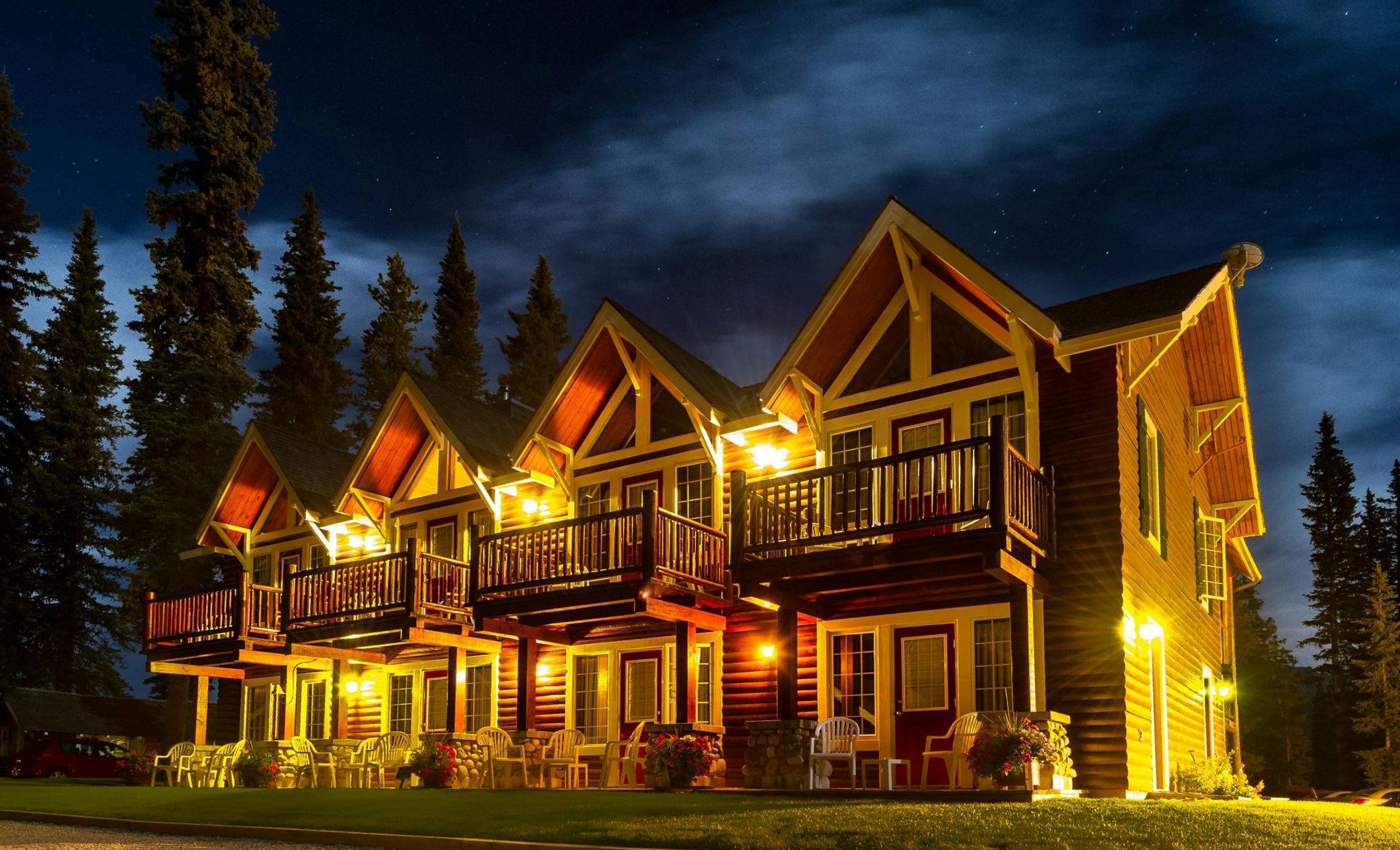 Lodge with private balconies and porches lit up at night with the stars above