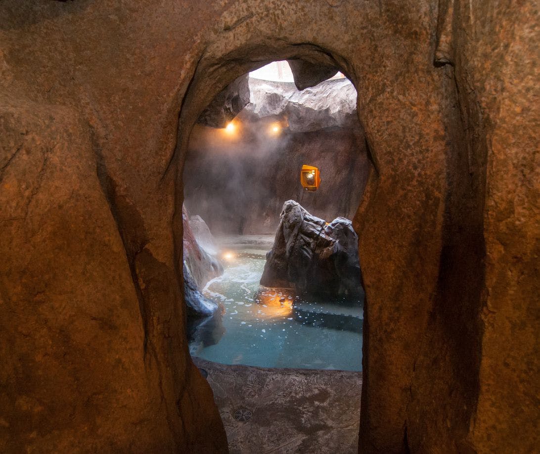 Peeking through a hole into a cave themed indoor swimming pool