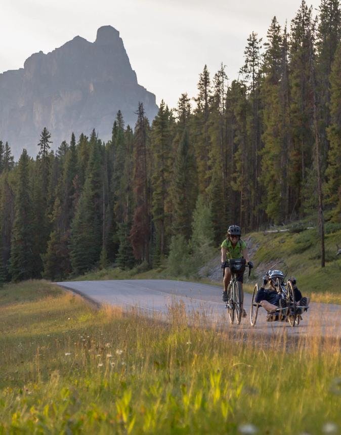 Two bike riders ride on the Bow Valley Parkway in Banff National Park.