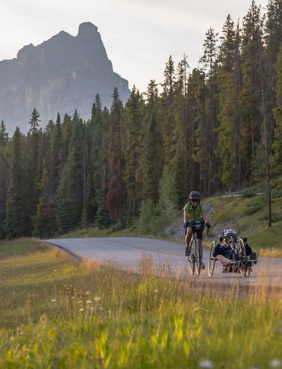 Two bike riders ride on the Bow Valley Parkway in Banff National Park.