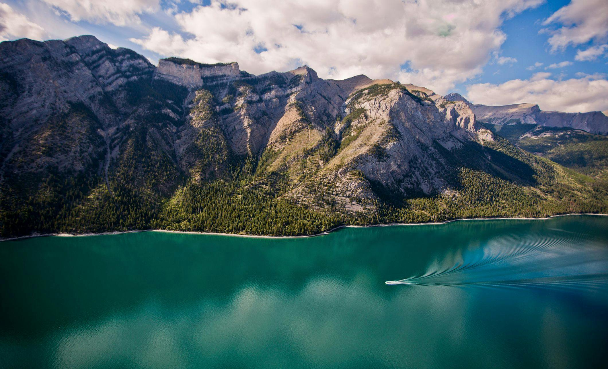 A boat tours the waters of Lake Minnewanka, Banff National Park, AB