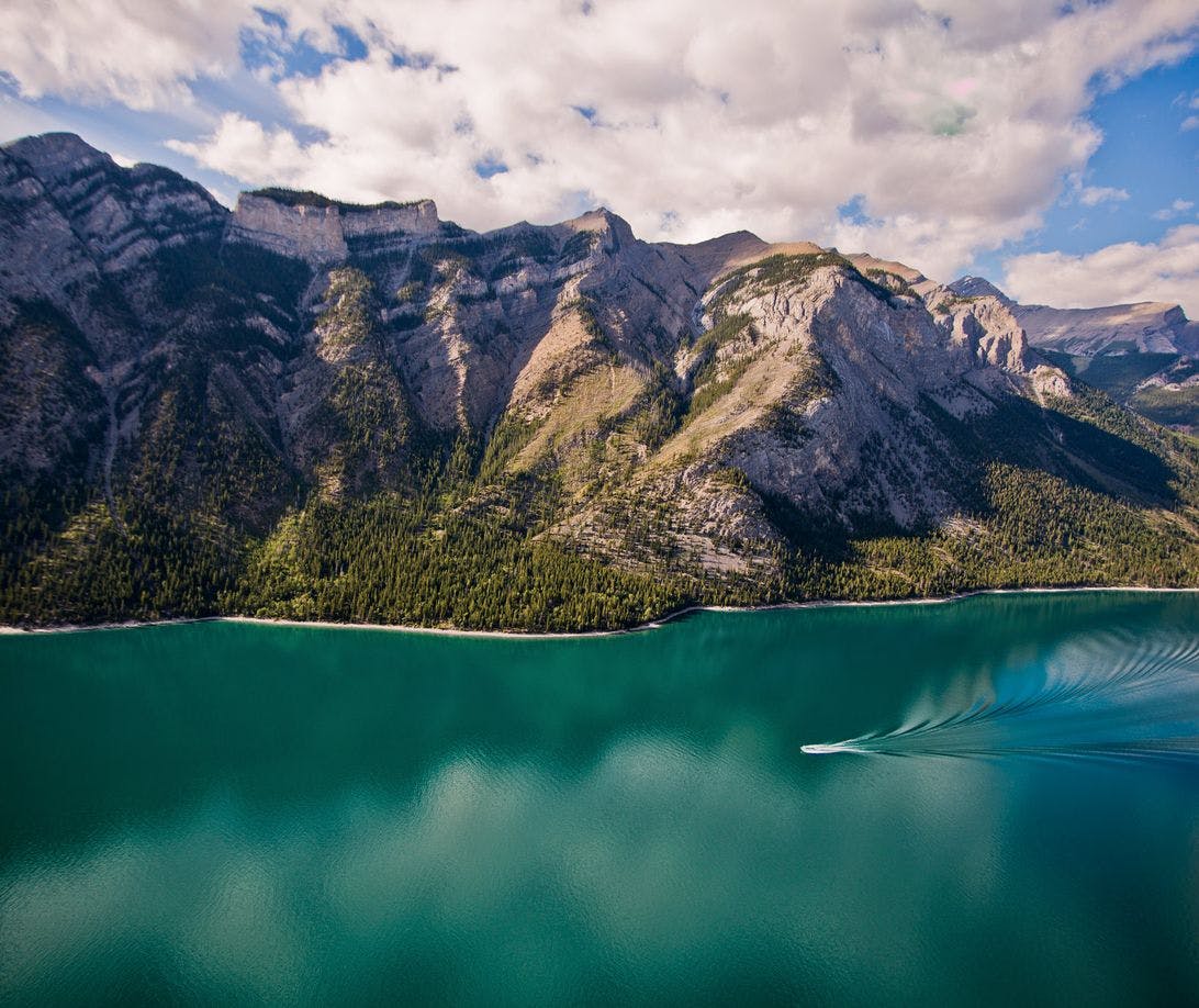 A boat tours the waters of Lake Minnewanka, Banff National Park, AB