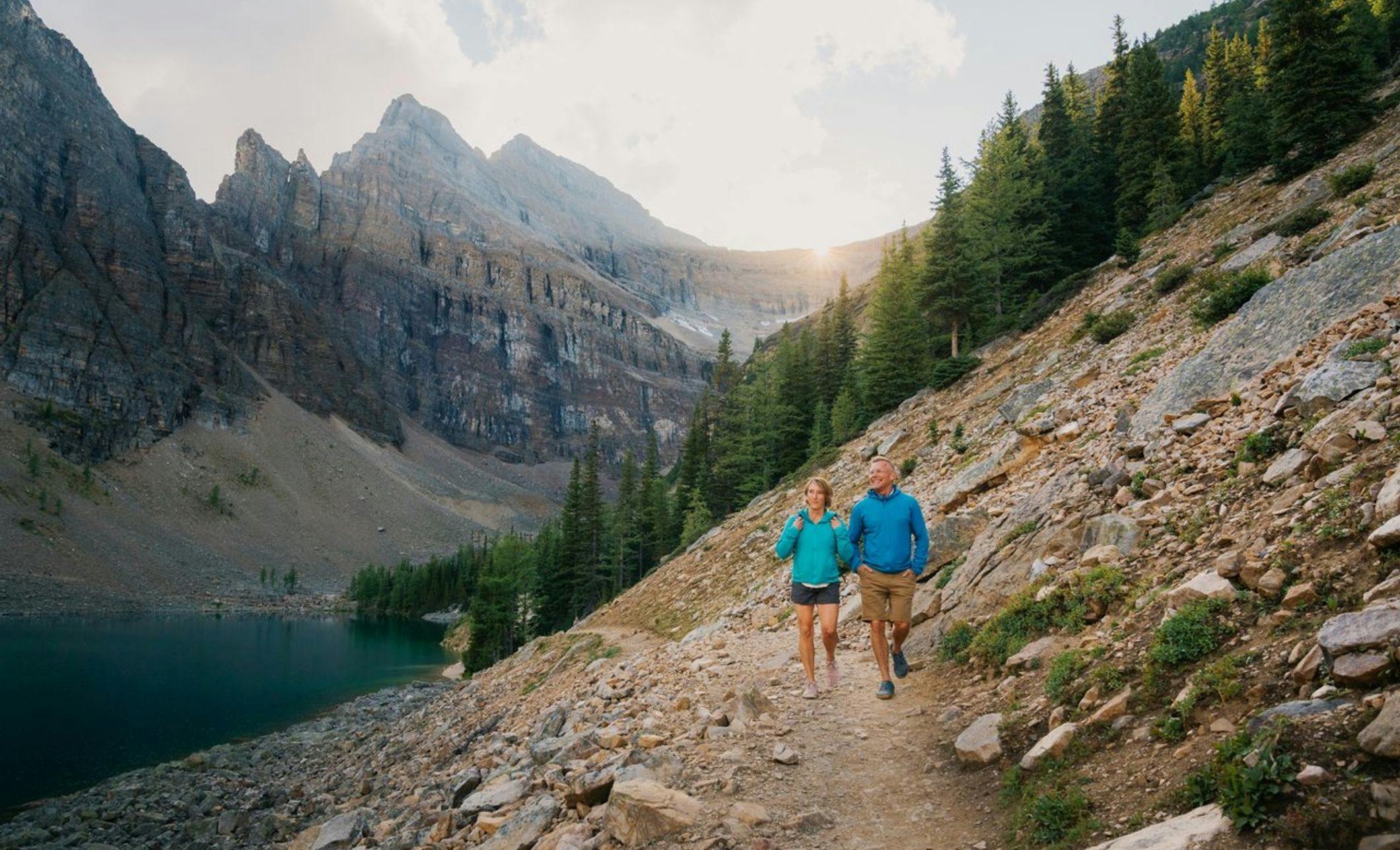 Two people hike a trail in Banff National Park in the Canadian Rockies.