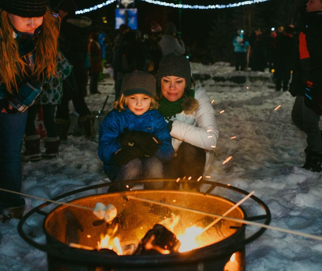 a mom and son roast marshmallows in Banff.