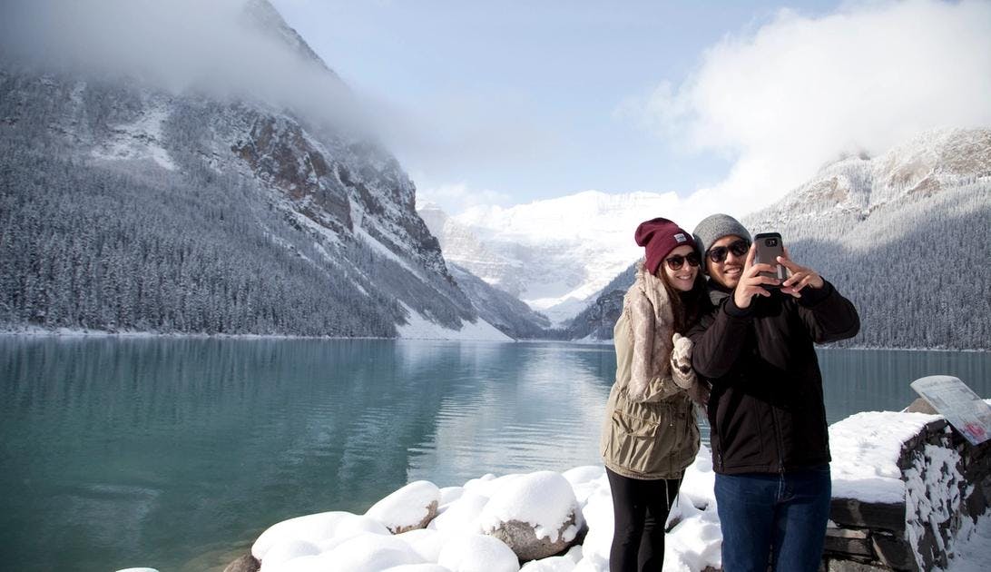 A couple takes a selfie at Lake Louise in the winter in Banff National Park.