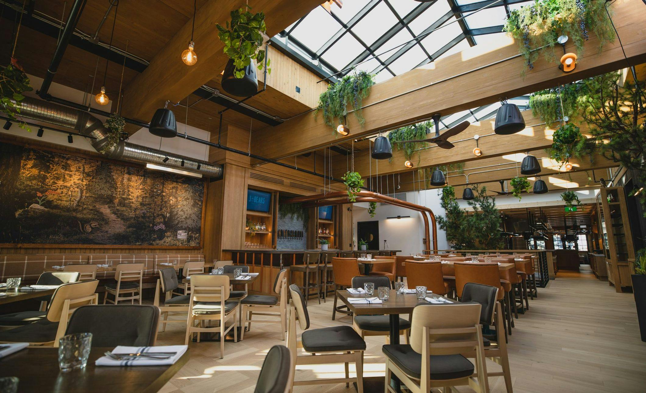 Restaurant seating with retractable glass roof and indoor plants 