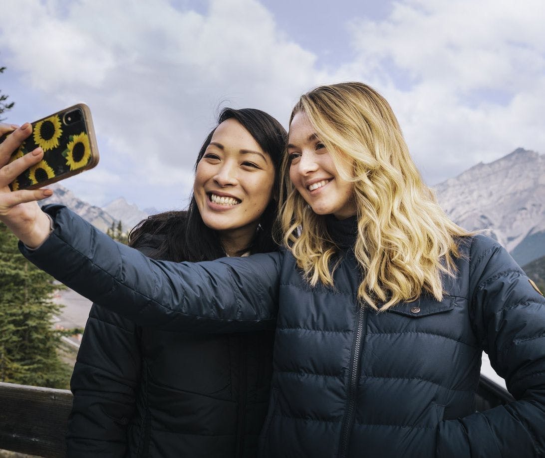 Two girls taking a selfie with mountains in the background