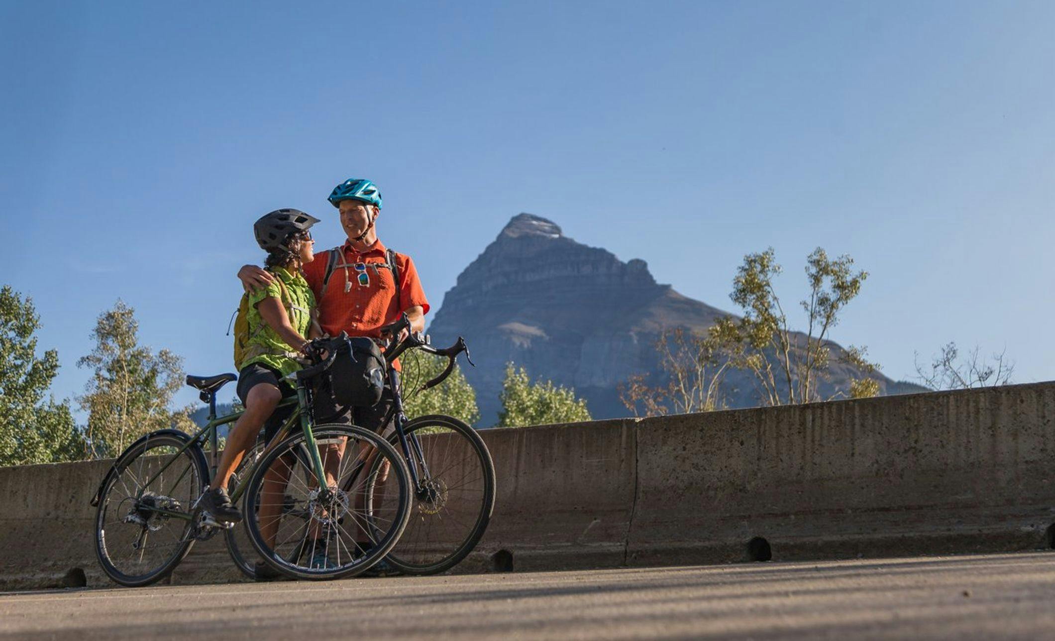 Two cyclists take a photo while riding the Bow Valley Parkway in Banff National Park.