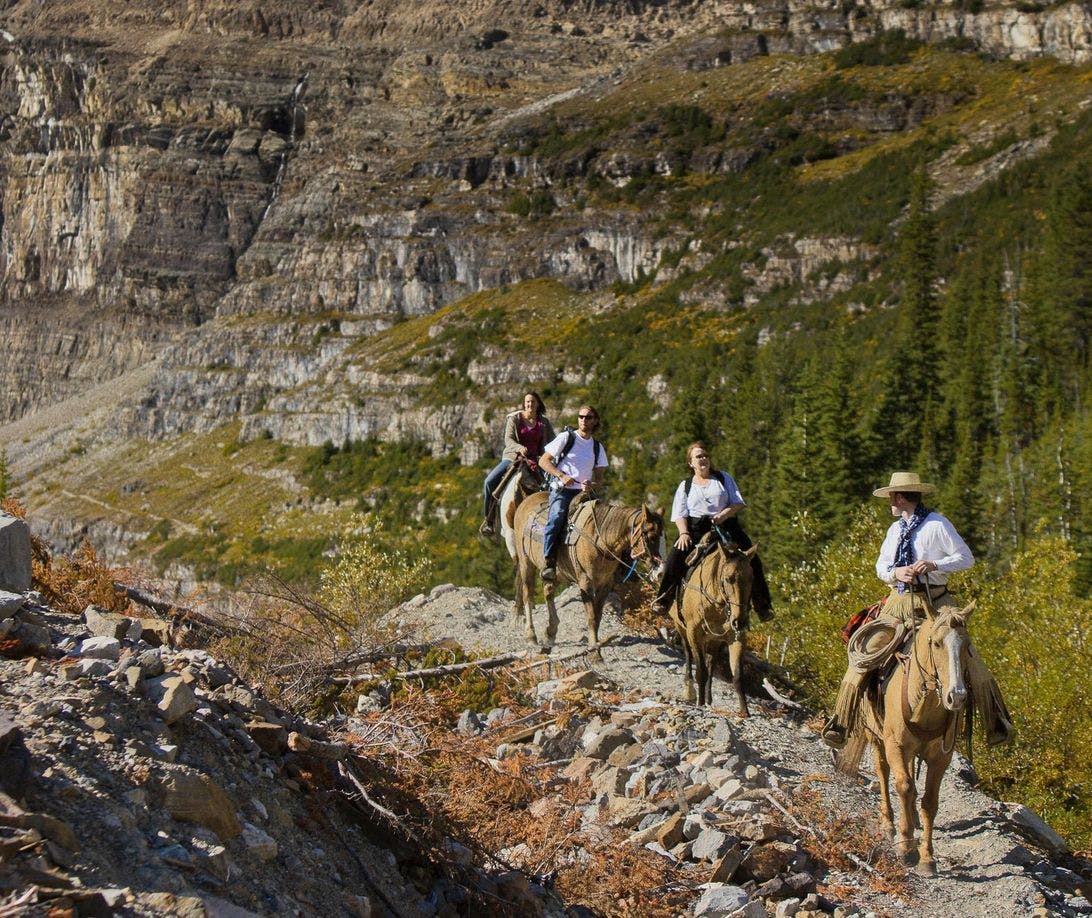 Horseback riders make their way through the alpine above Banff and Lake Louise, AB
