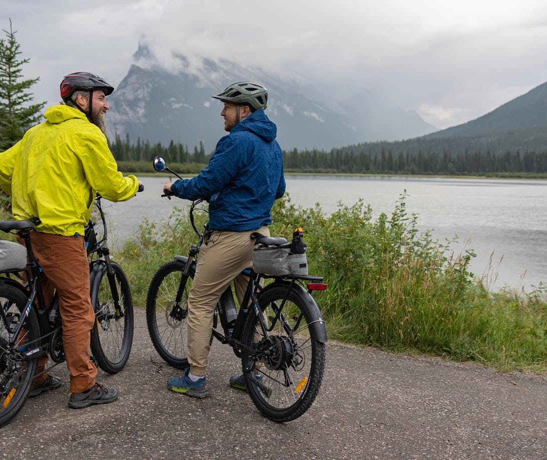 Two bike riders look at the view of Mount Rundle on Vermilion Lakes Road.