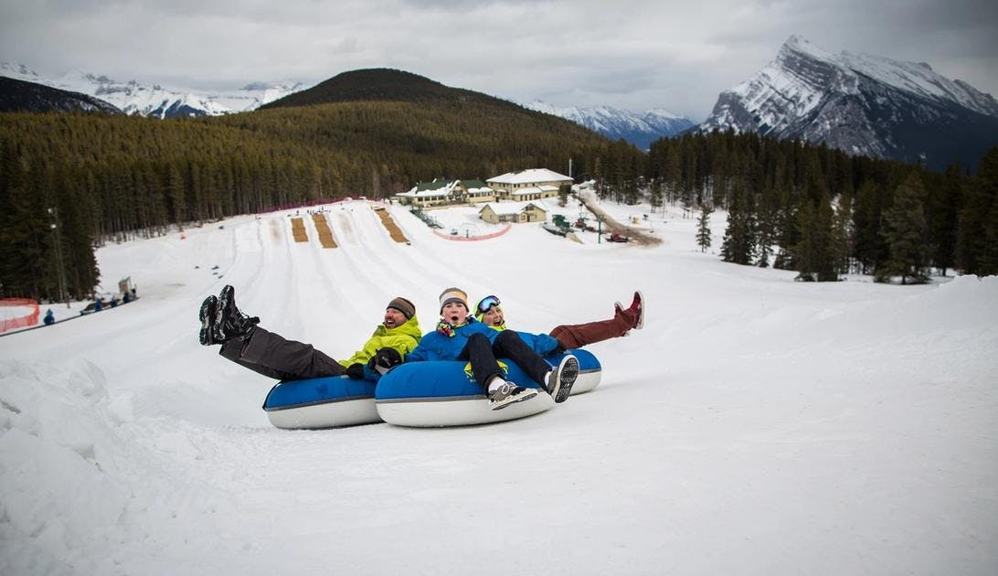 A family tubes on the snowy slopes of Banff and Lake Louise, AB