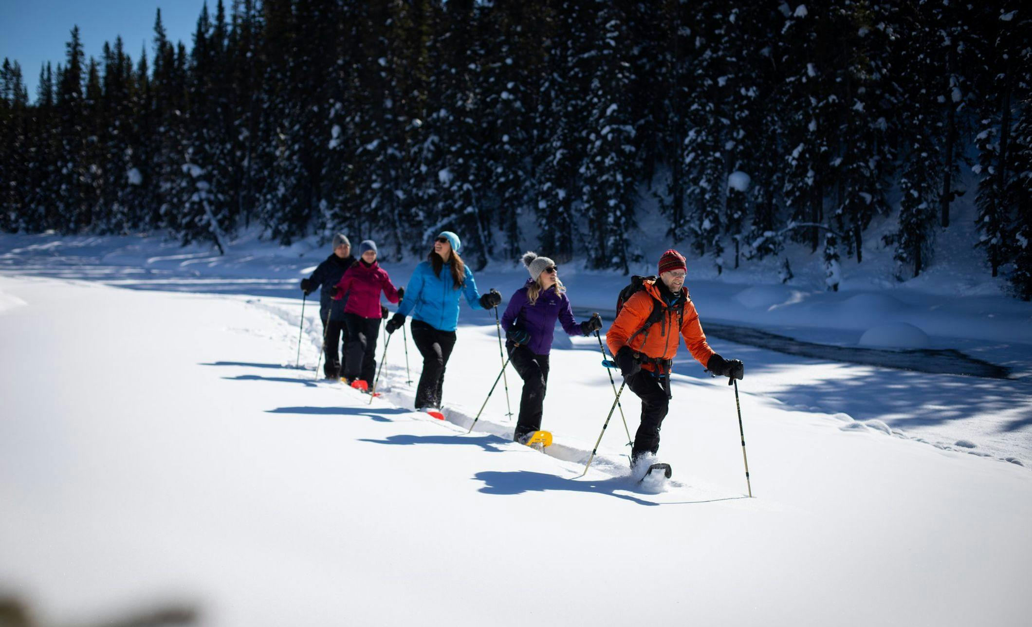 A group touring on snowshoes through deep snow