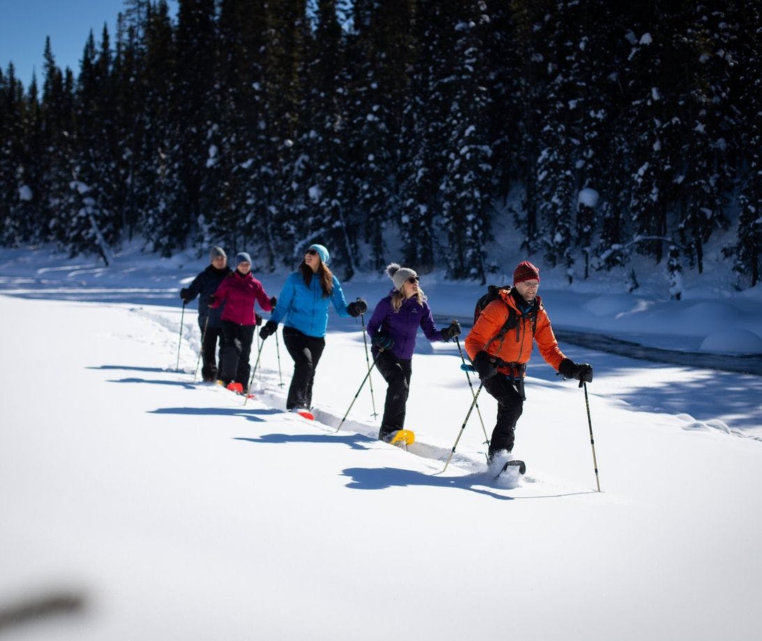 A group touring on snowshoes through deep snow