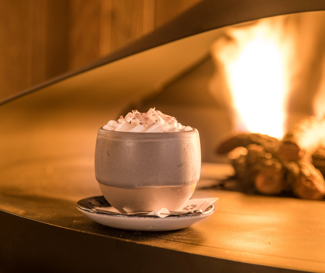 A hot chocolate on the edge of a firepit at Bluebird Restaurant.