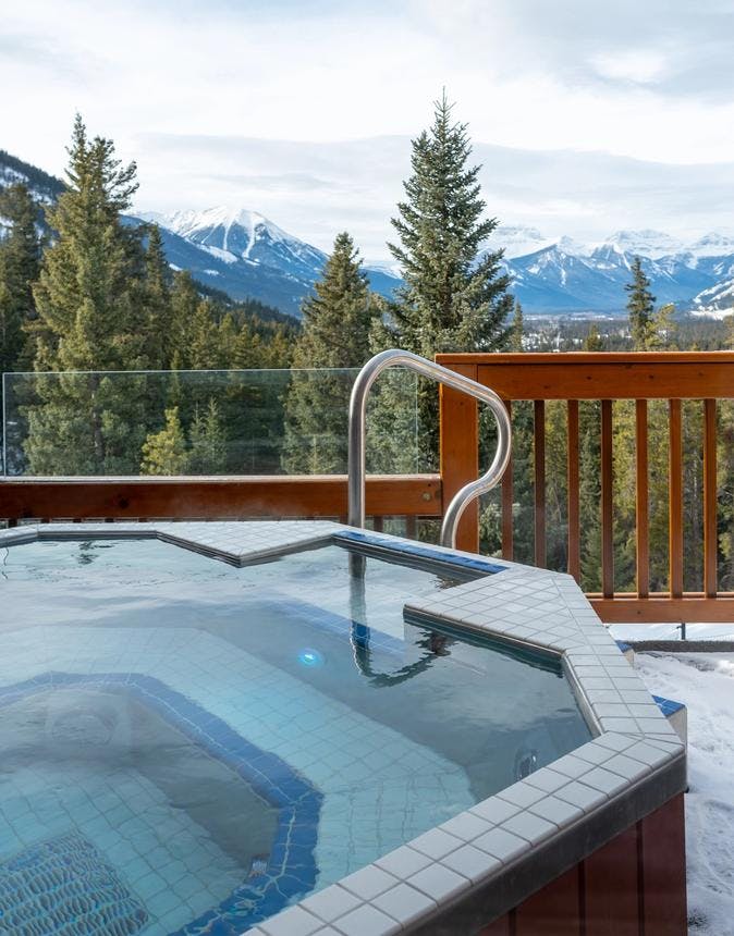 Outdoor Hot Tub on a balcony with winter mountains in the background