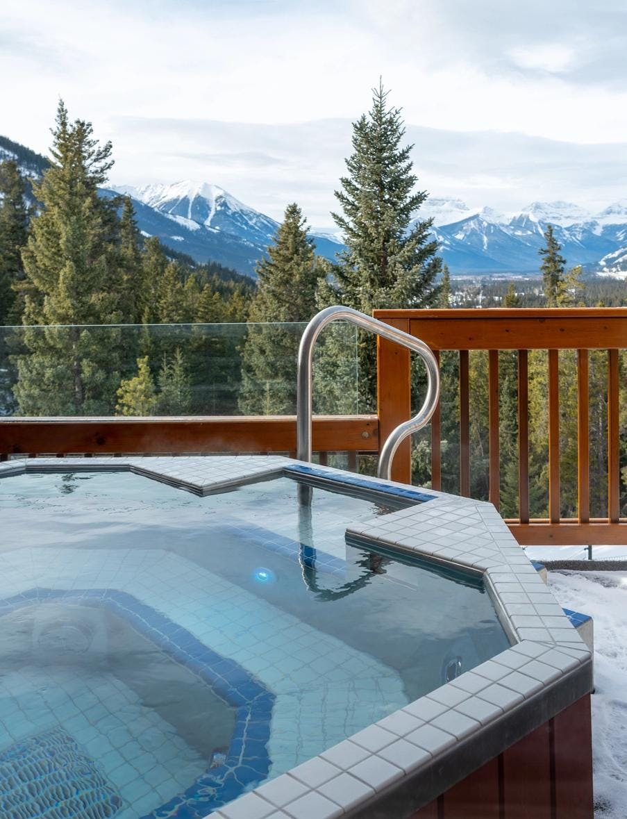 Outdoor Hot Tub on a balcony with winter mountains in the background