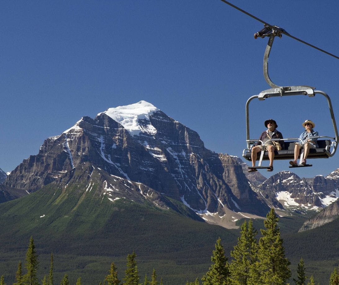 Couple riding open chairlift at Lake Louise Sightseeing Gondola