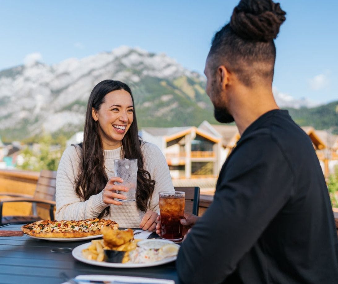 A couple enjoy a patio in Banff